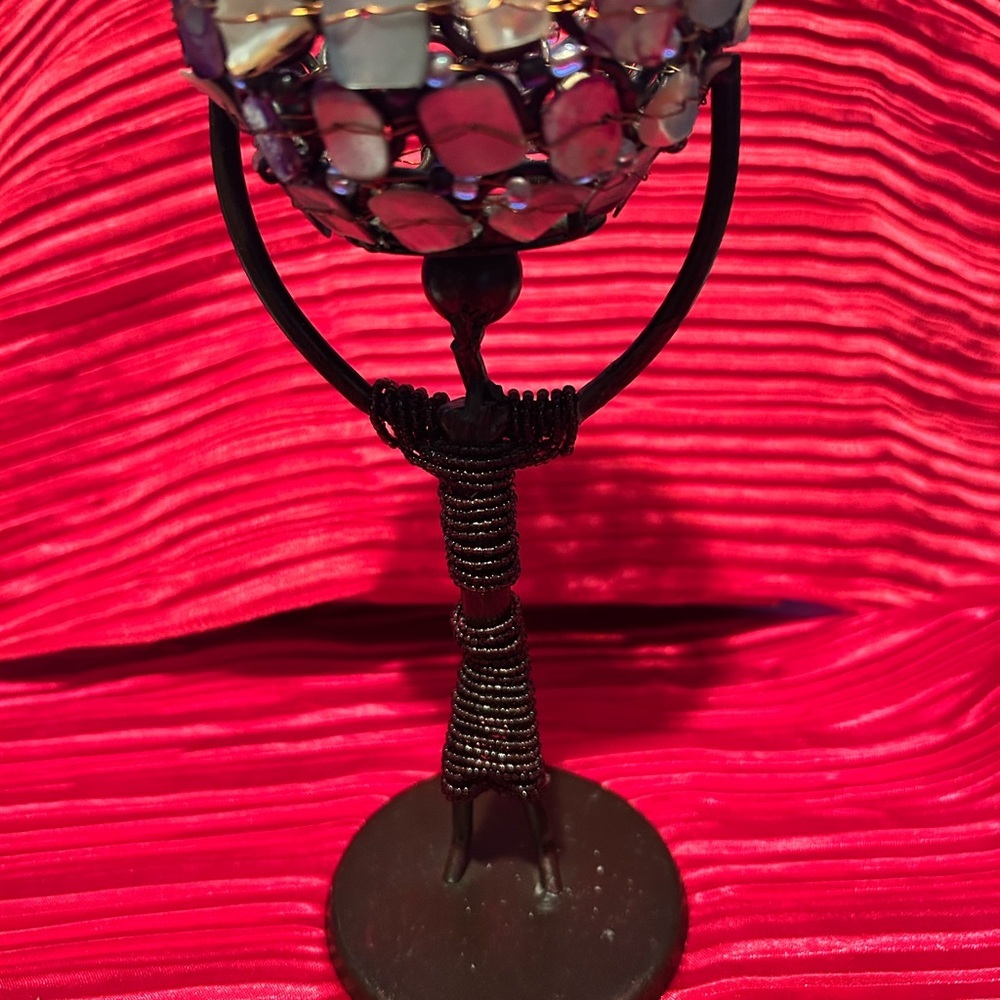 African stir of a man holding an abalone and wire basket over his head- preloved